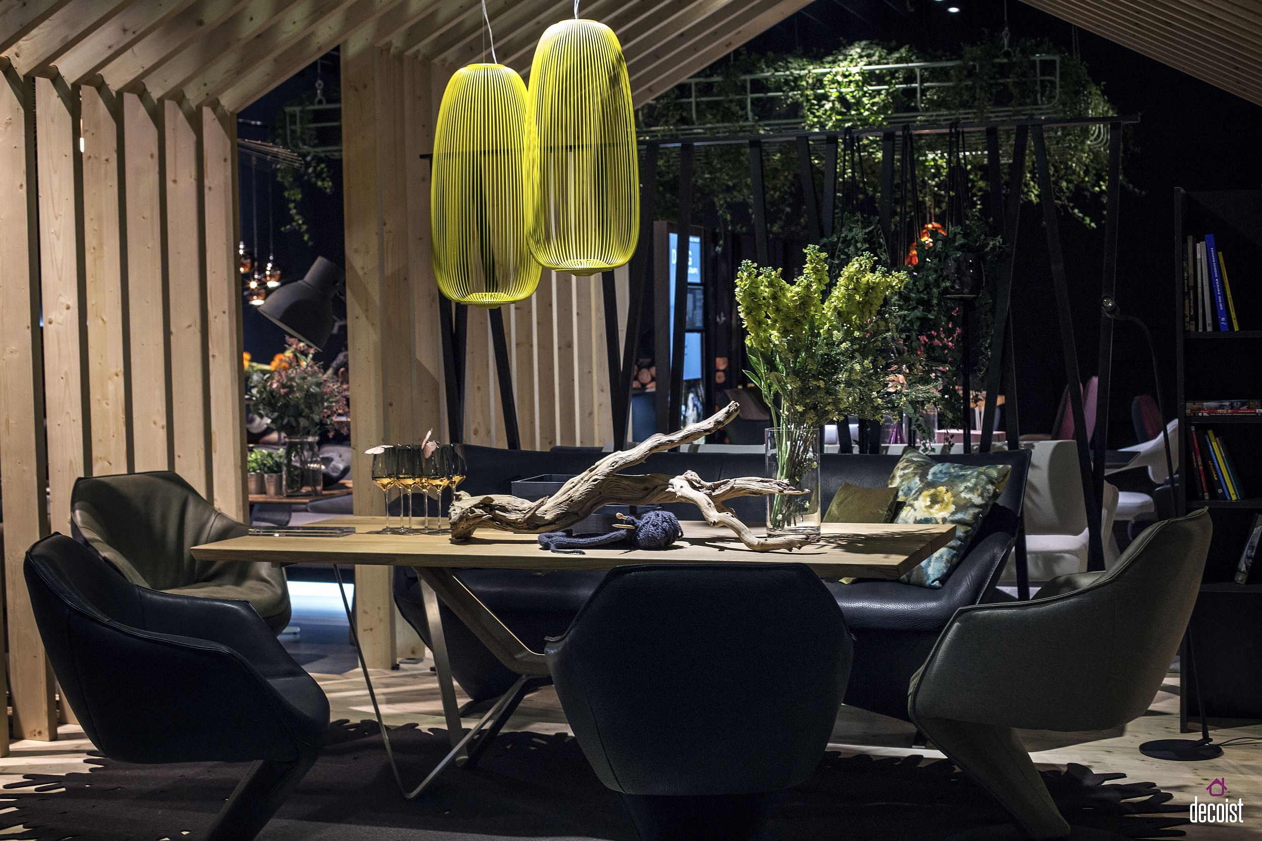 Dining room with ingenious lighting, cushioned couch and leather chairs