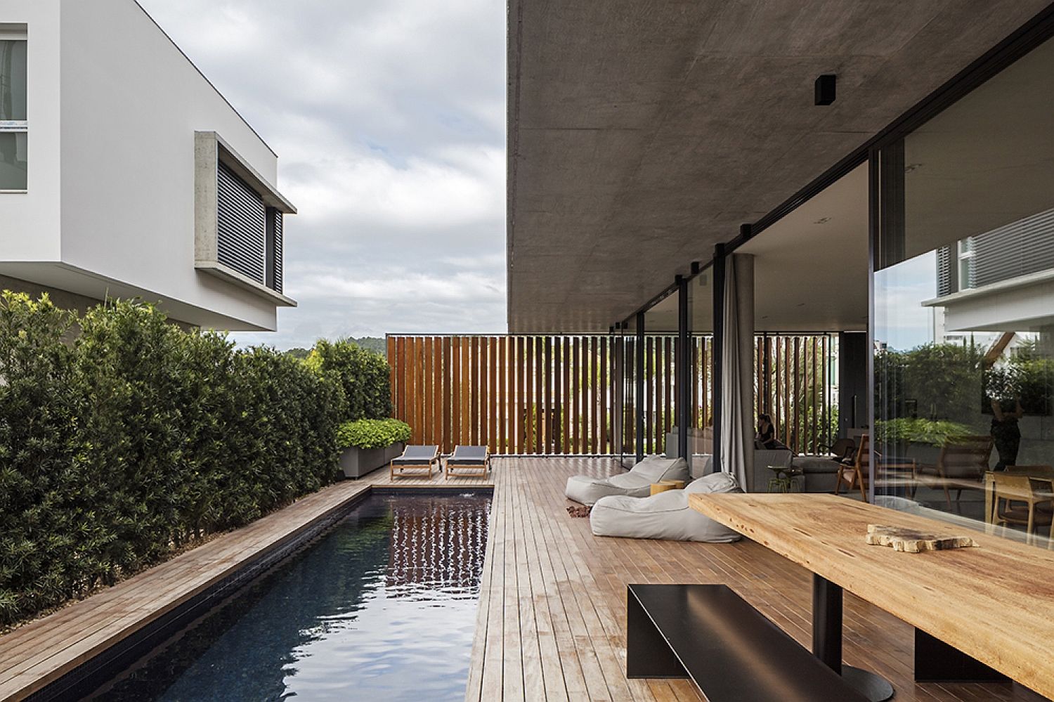 Expansive wooden deck and pool connecetd with ground level living area