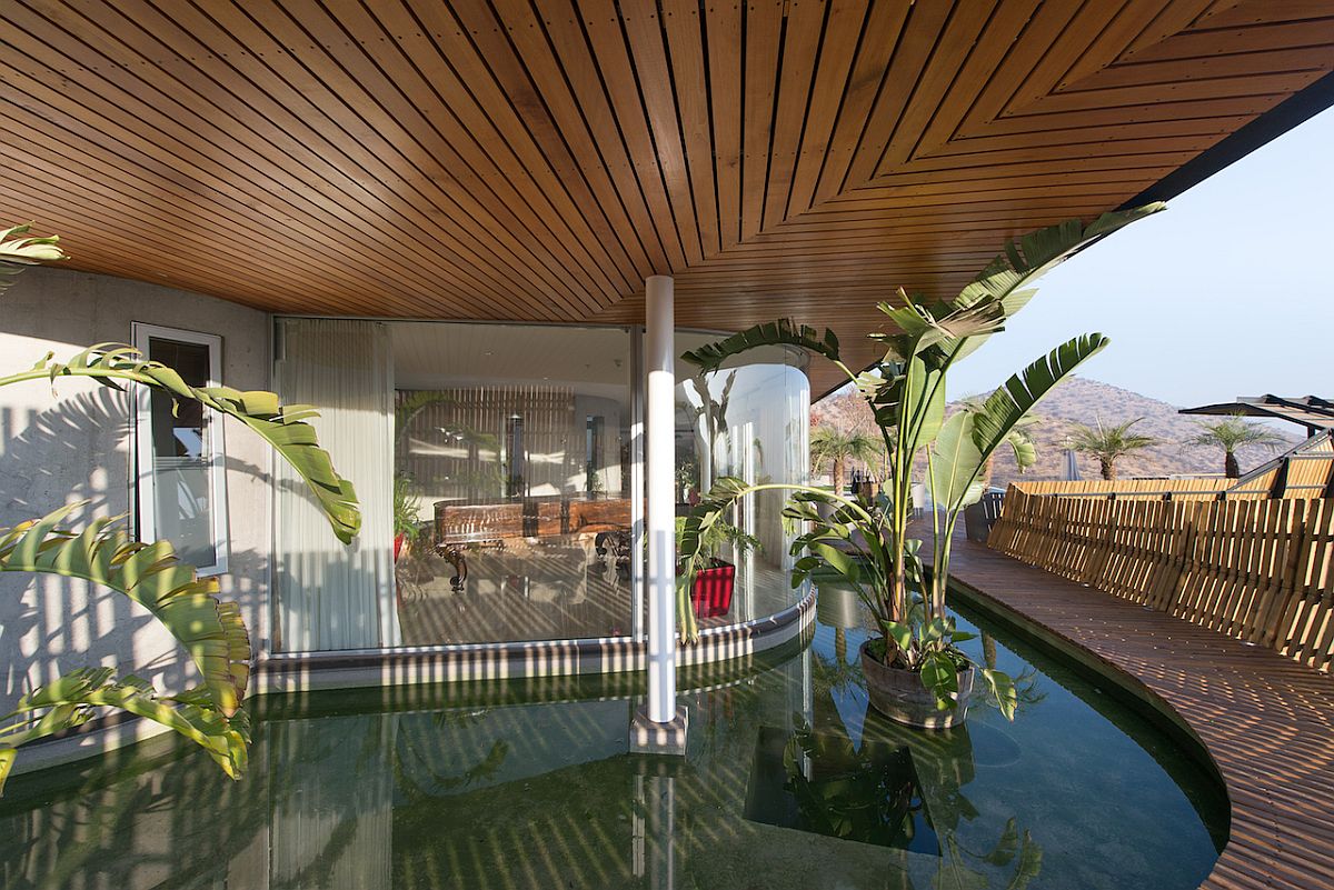 Exquisite wooden deck and reflecting pond around the Chilean home help regulate temperature