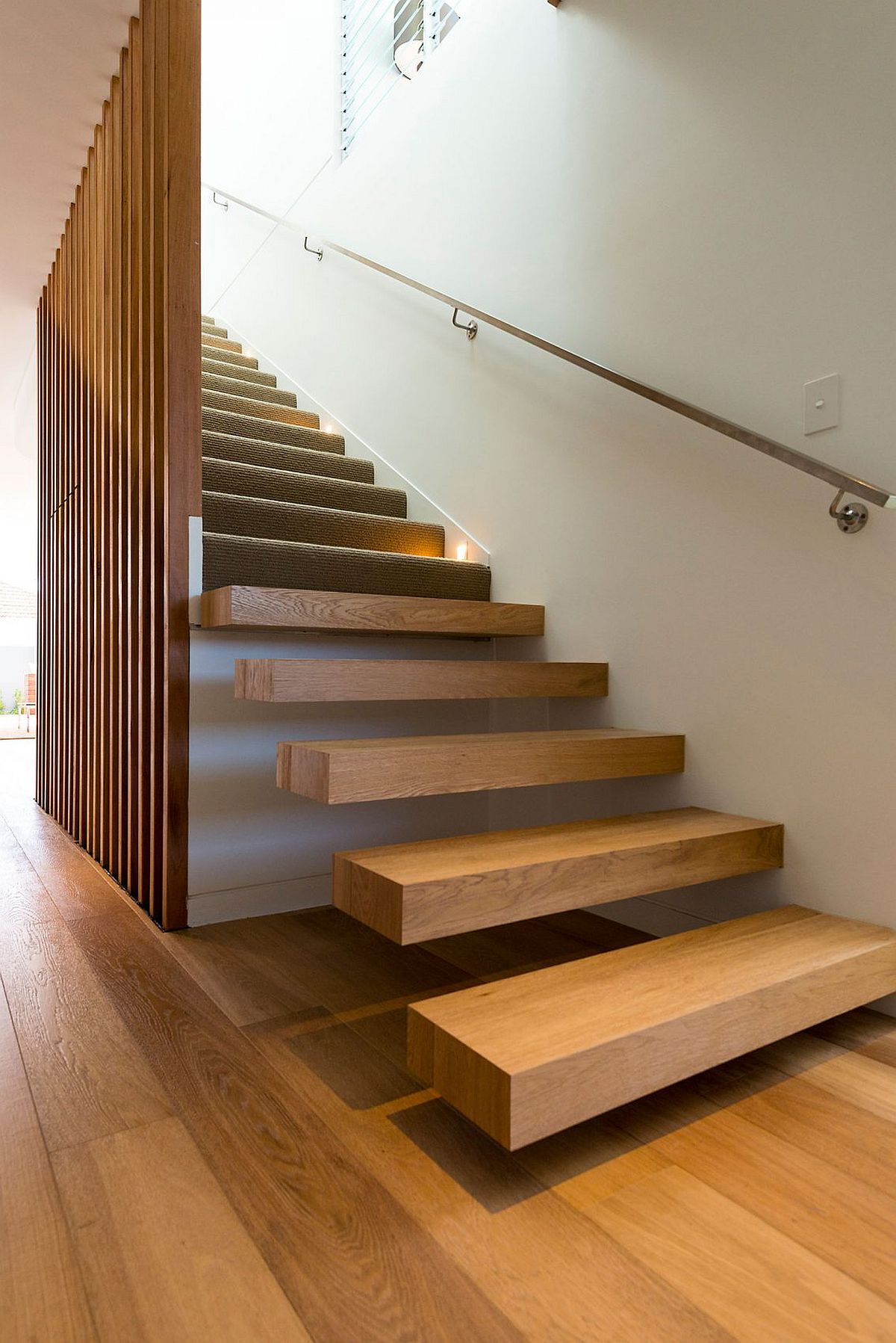 Floating wooden staircase with wooden slats inisde the contemporary home