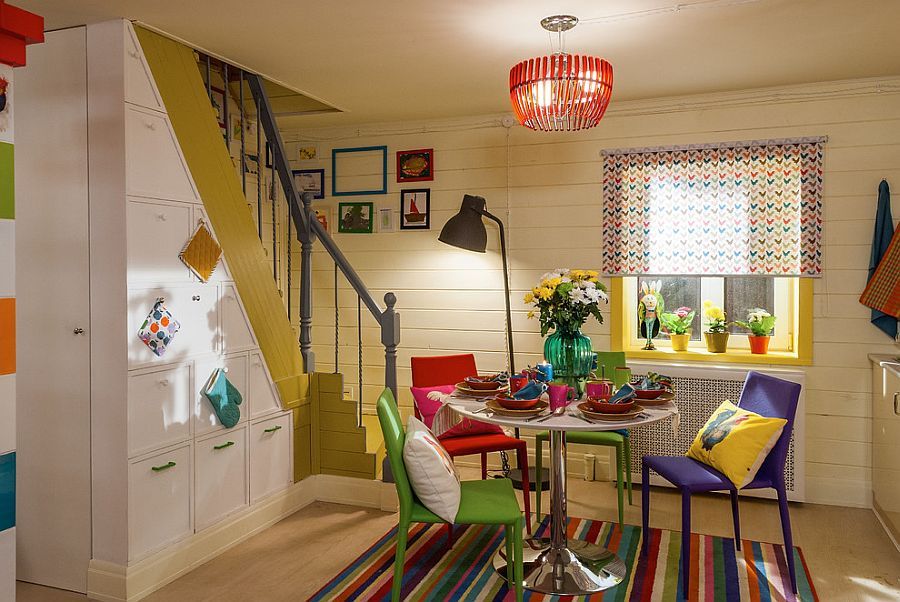 Gorgeously eclectic dining room with multi-colored chairs and a vivacious rug