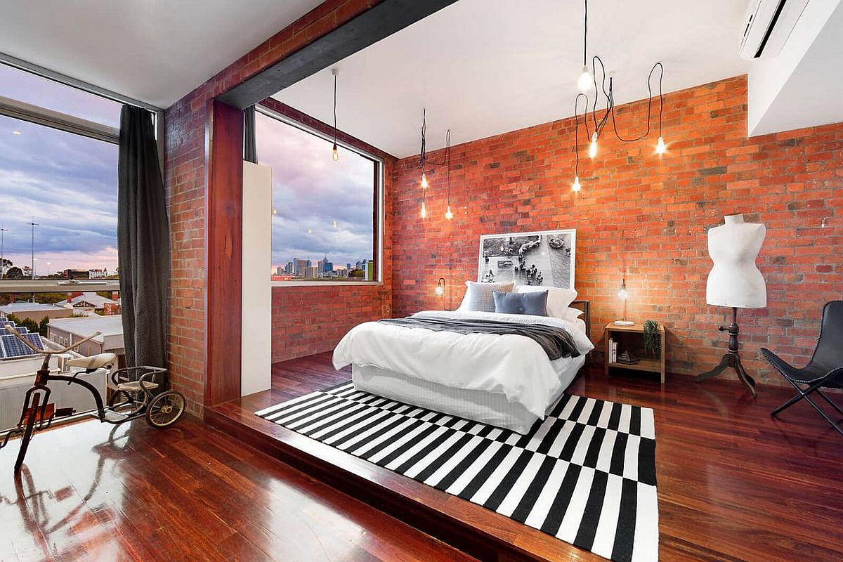 Industrial bedroom with brick walls and ample lighting