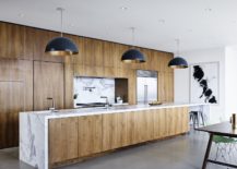 Kitchen-island-in-wood-with-marble-countertop-and-dark-pendants-above-217x155
