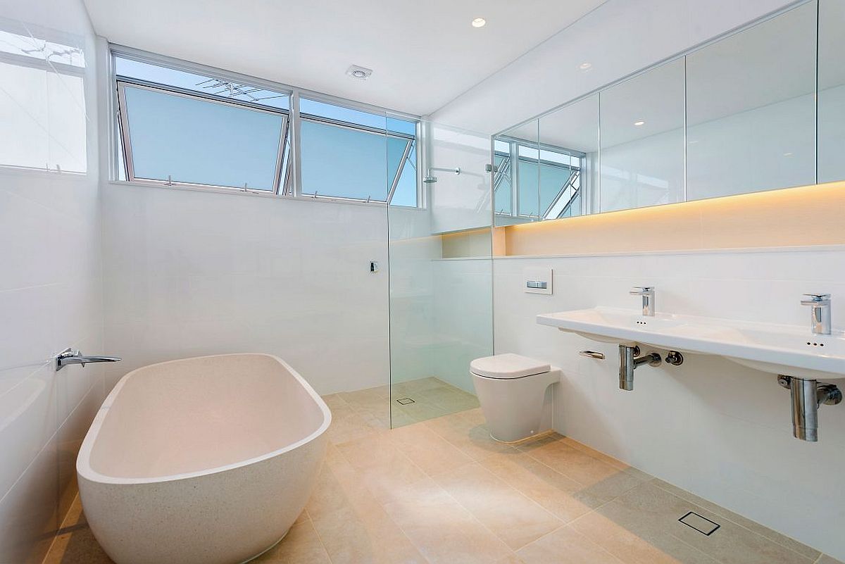 LED strip lighting adds charm to the stylish contemporary bathroom in white