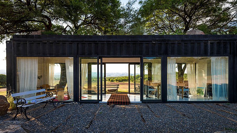 Large glass walls and sliding glass doors transform the shipping container