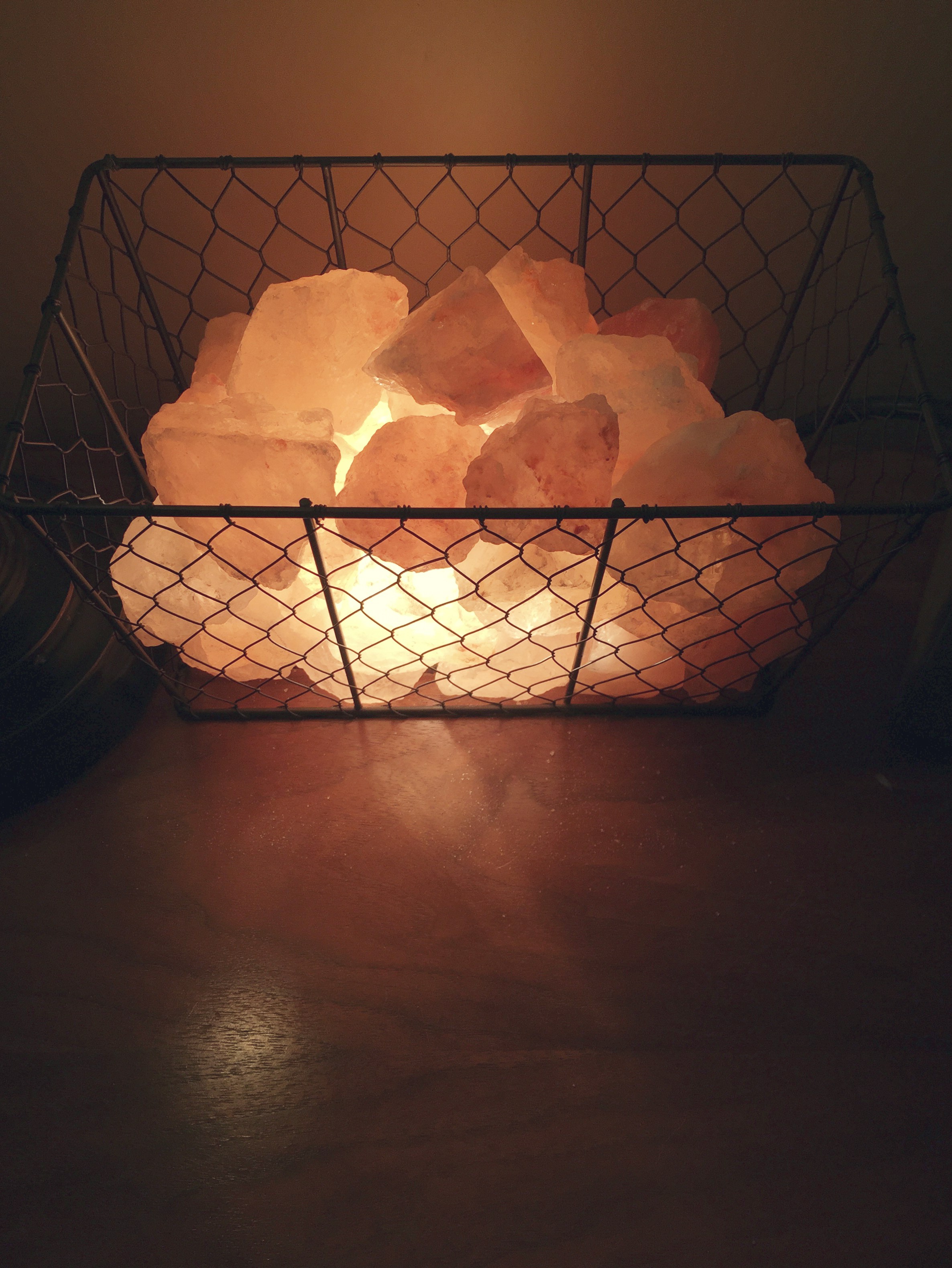 Lit up salt crystal pieces within a wire basket create a unique salt lamp installation