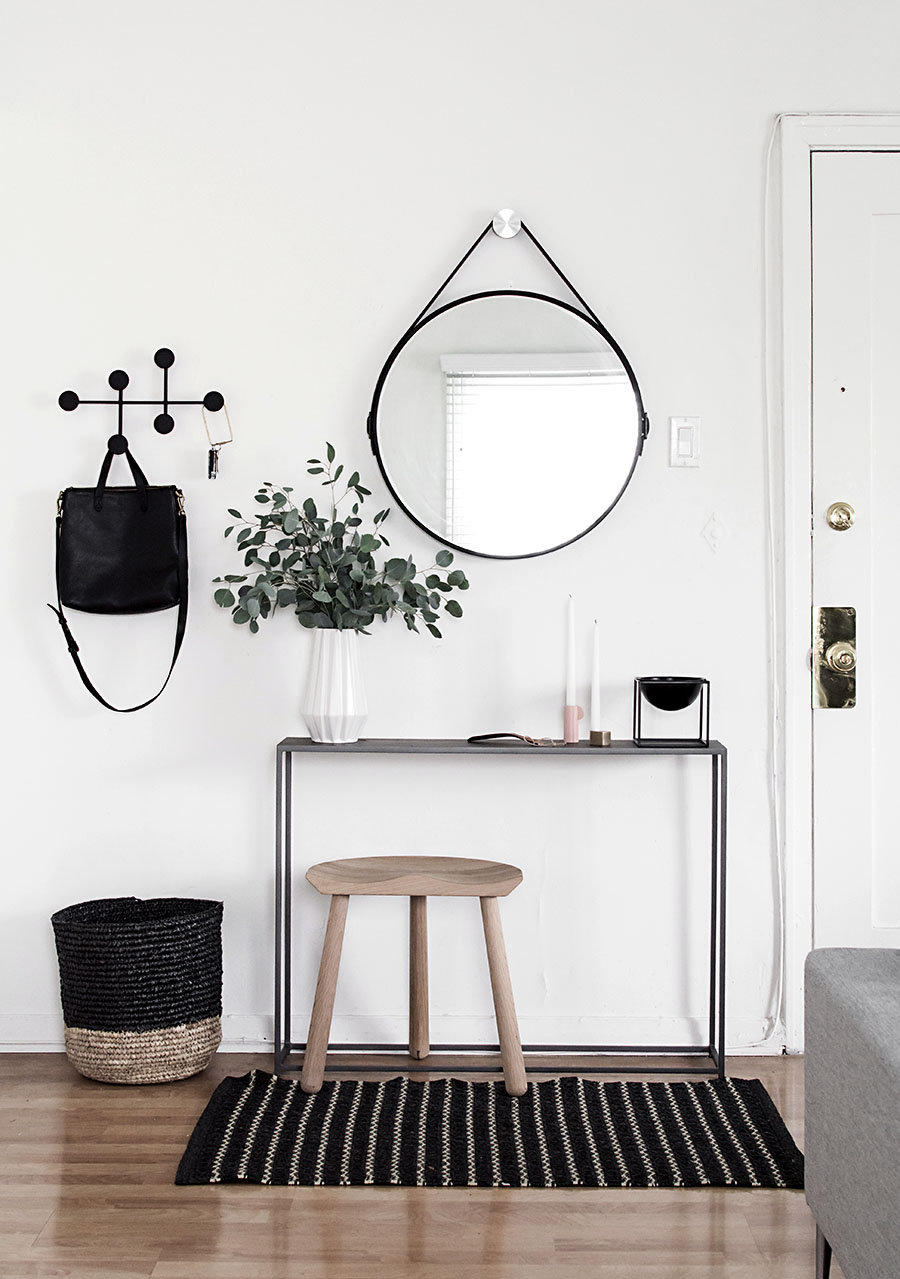 Minimalist entryway decorated in black, white and wood