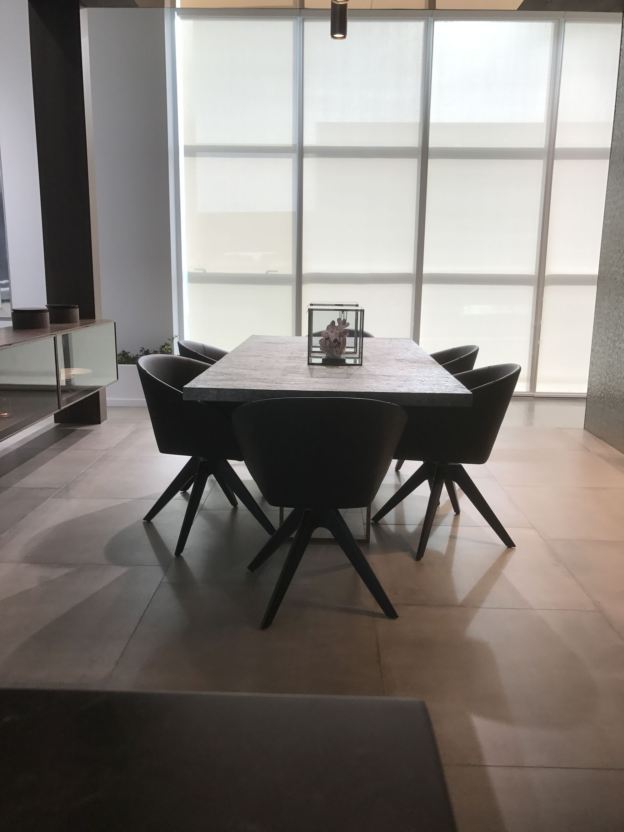Modern dining area with marble inspired table and large floor tiles by Porcelanosa