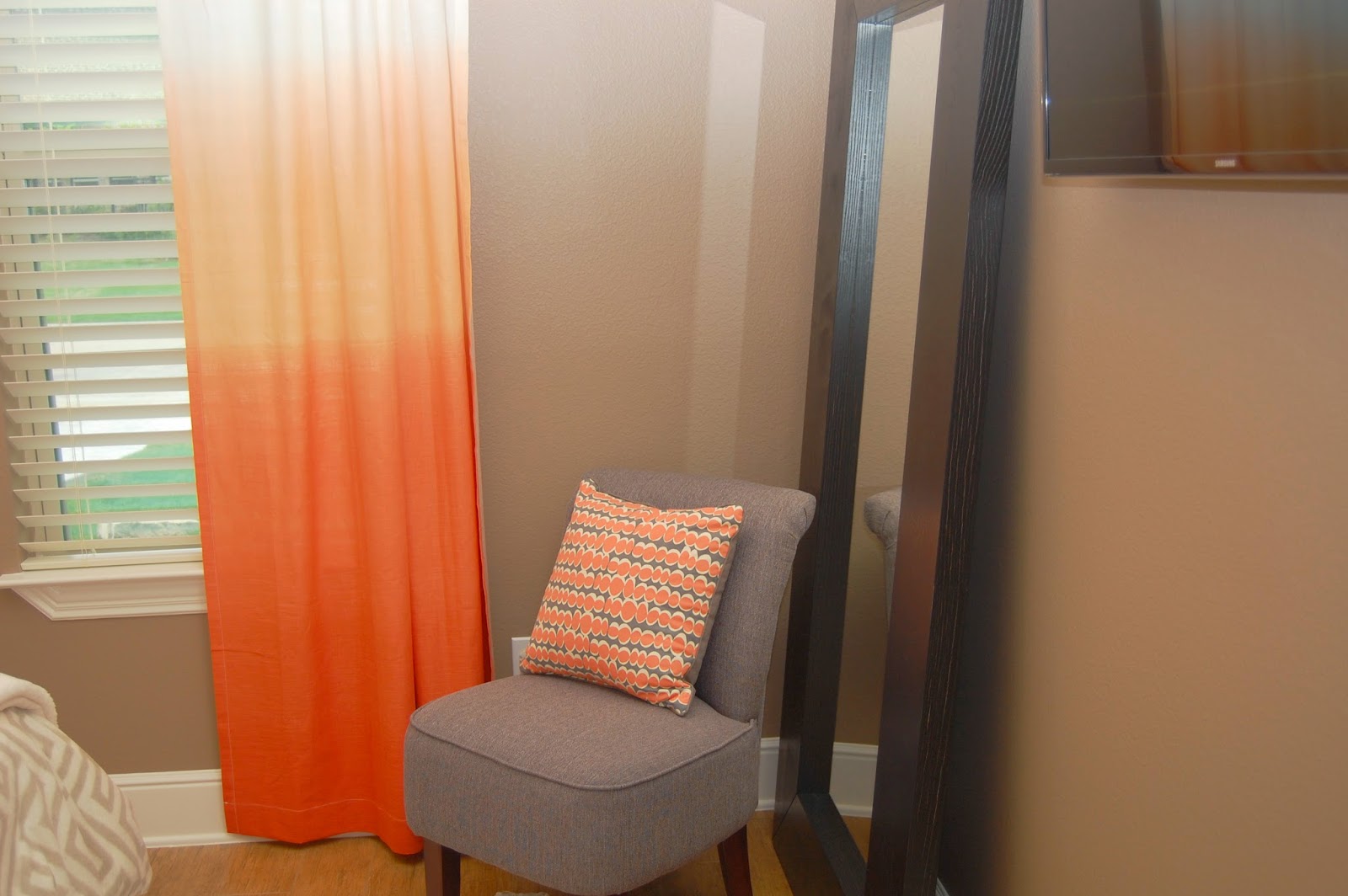 Orange ombre curtains contrast the neutral decor