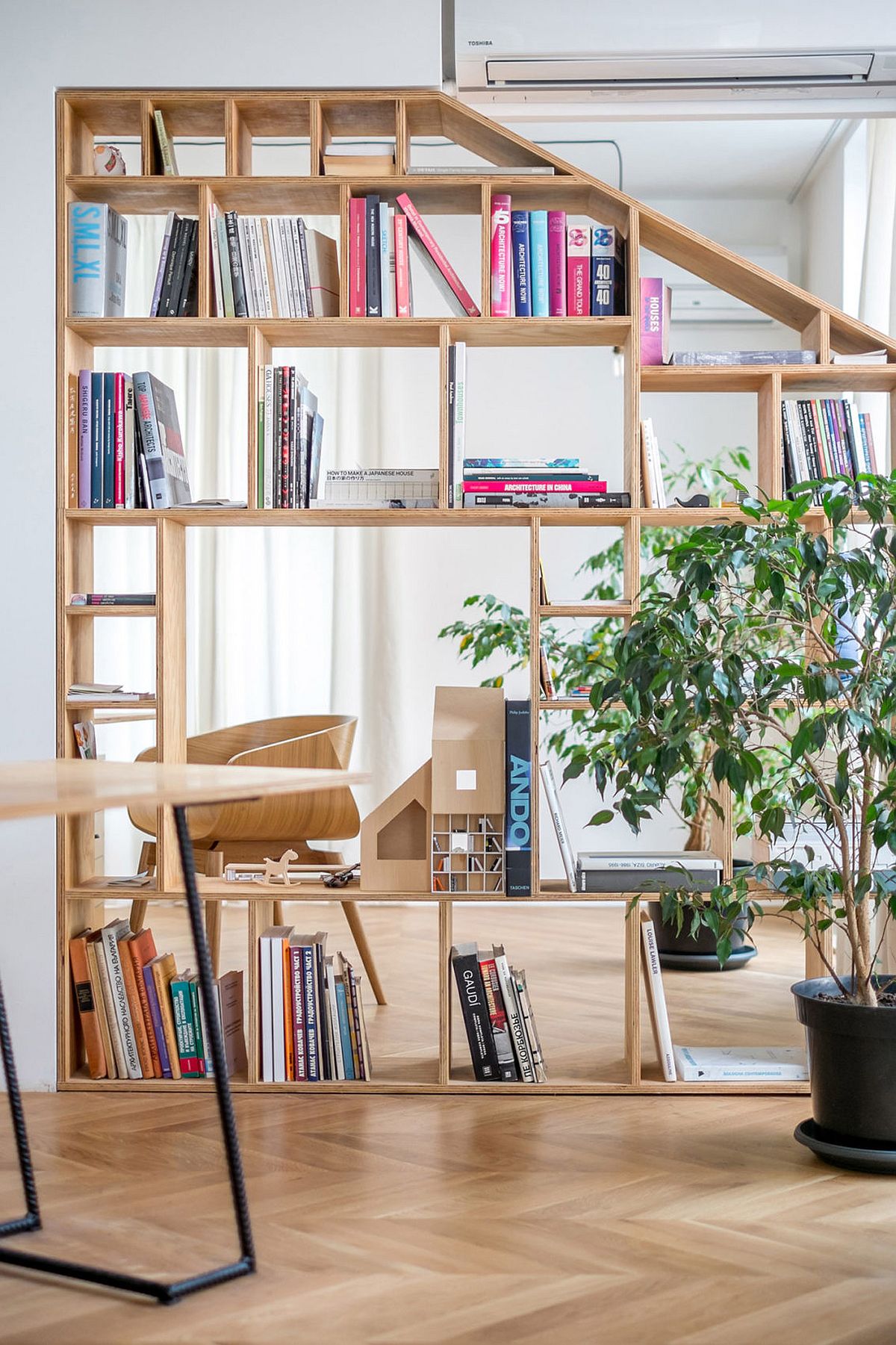 Plywood partitions with shelves and cabinets delineate space witout creating an obstruction