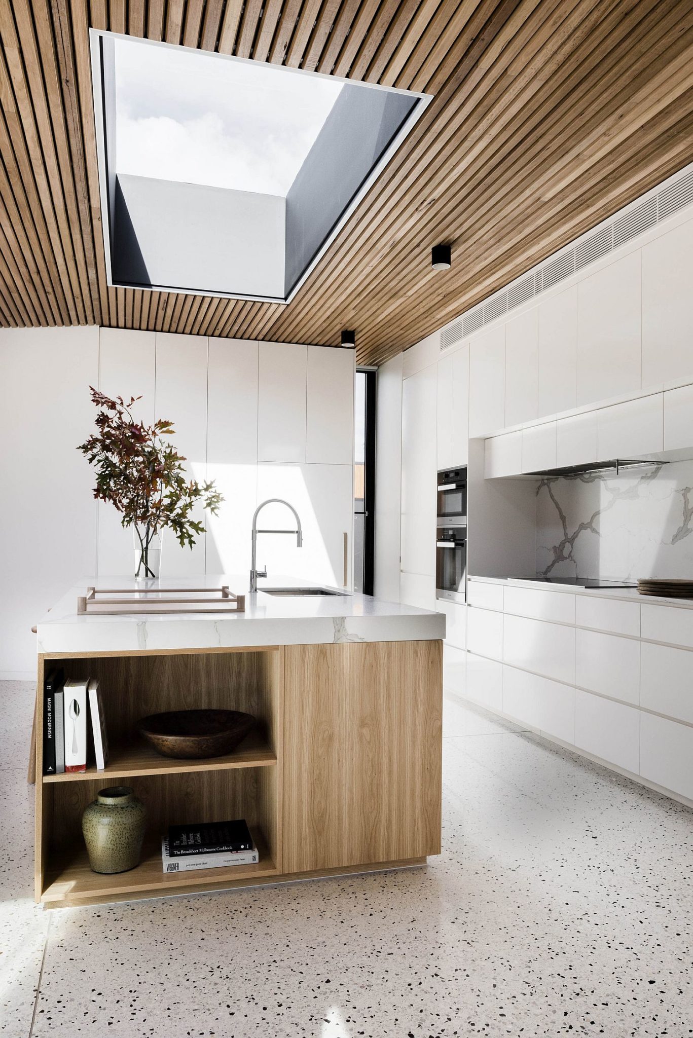 Skylight brings natural ventilation to the kitchen with wooden ceiling