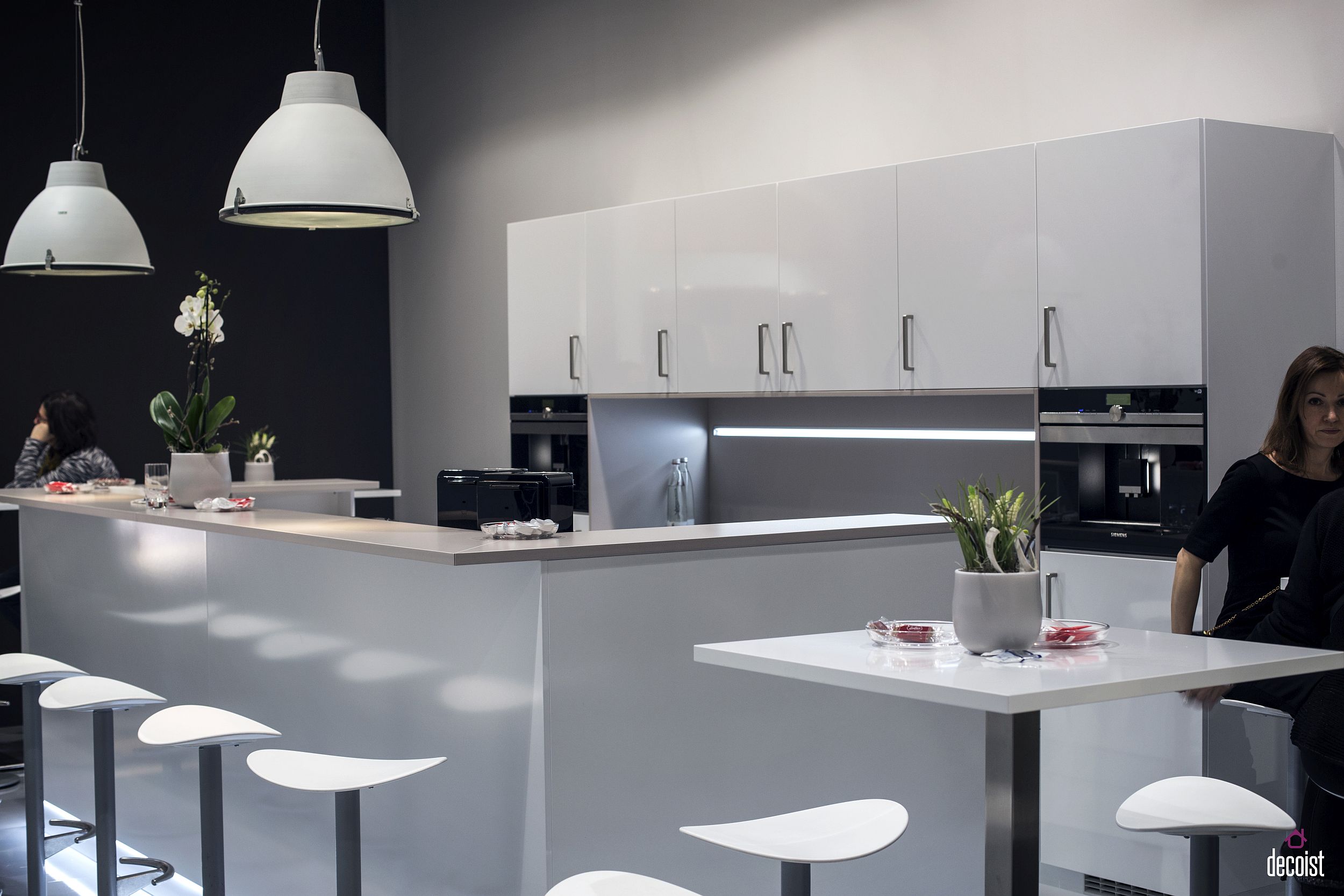 Slim breakfast bar top along with additional sitting and counter space in the white kitchen