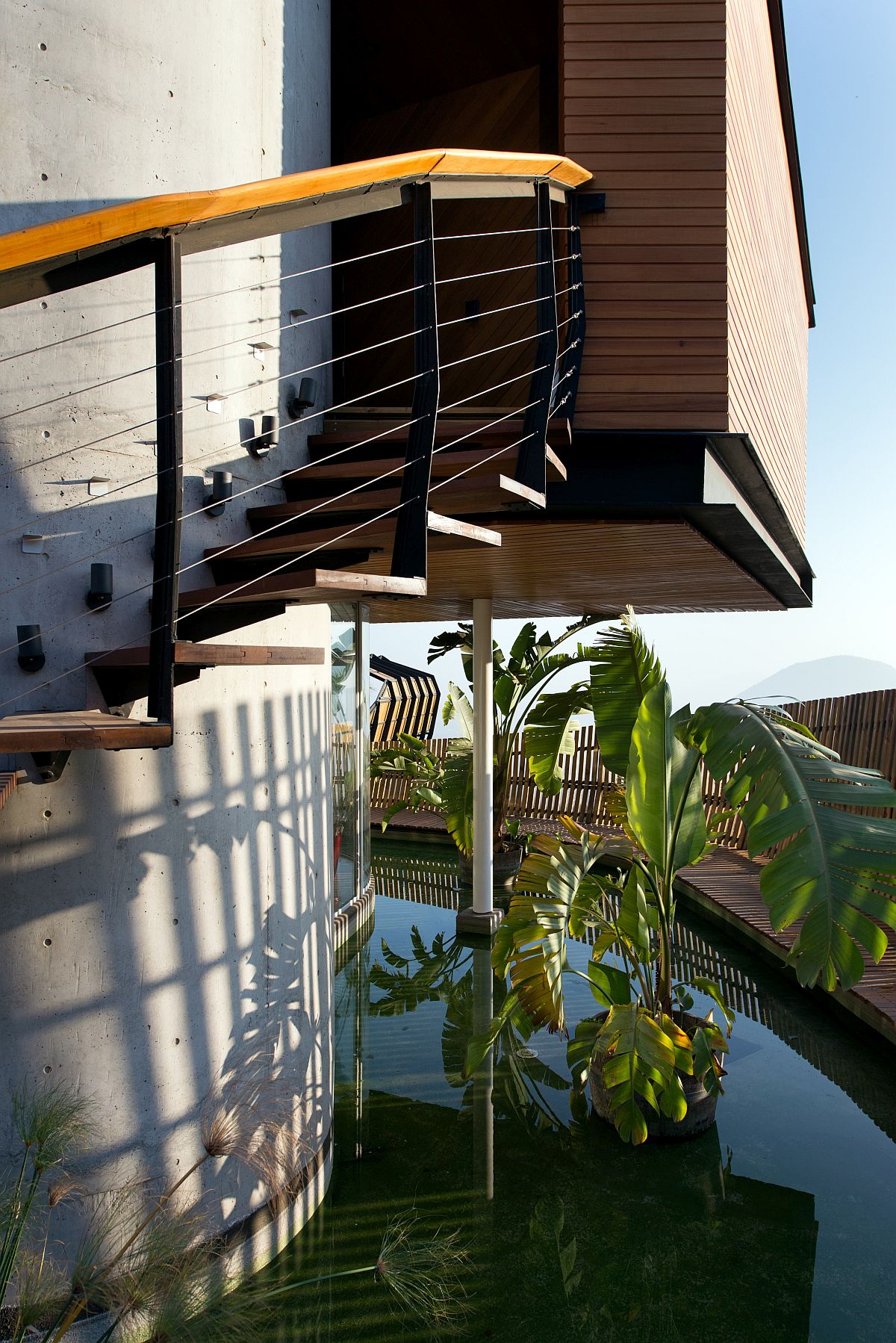 Stairwell with spiral staircase on the outside and a reflecting pond next to it