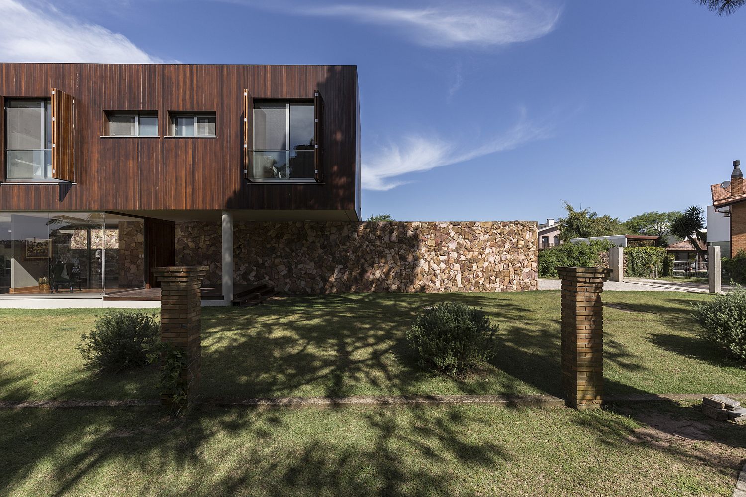 Stone wall made from local stone with cantilevered structure of the home above