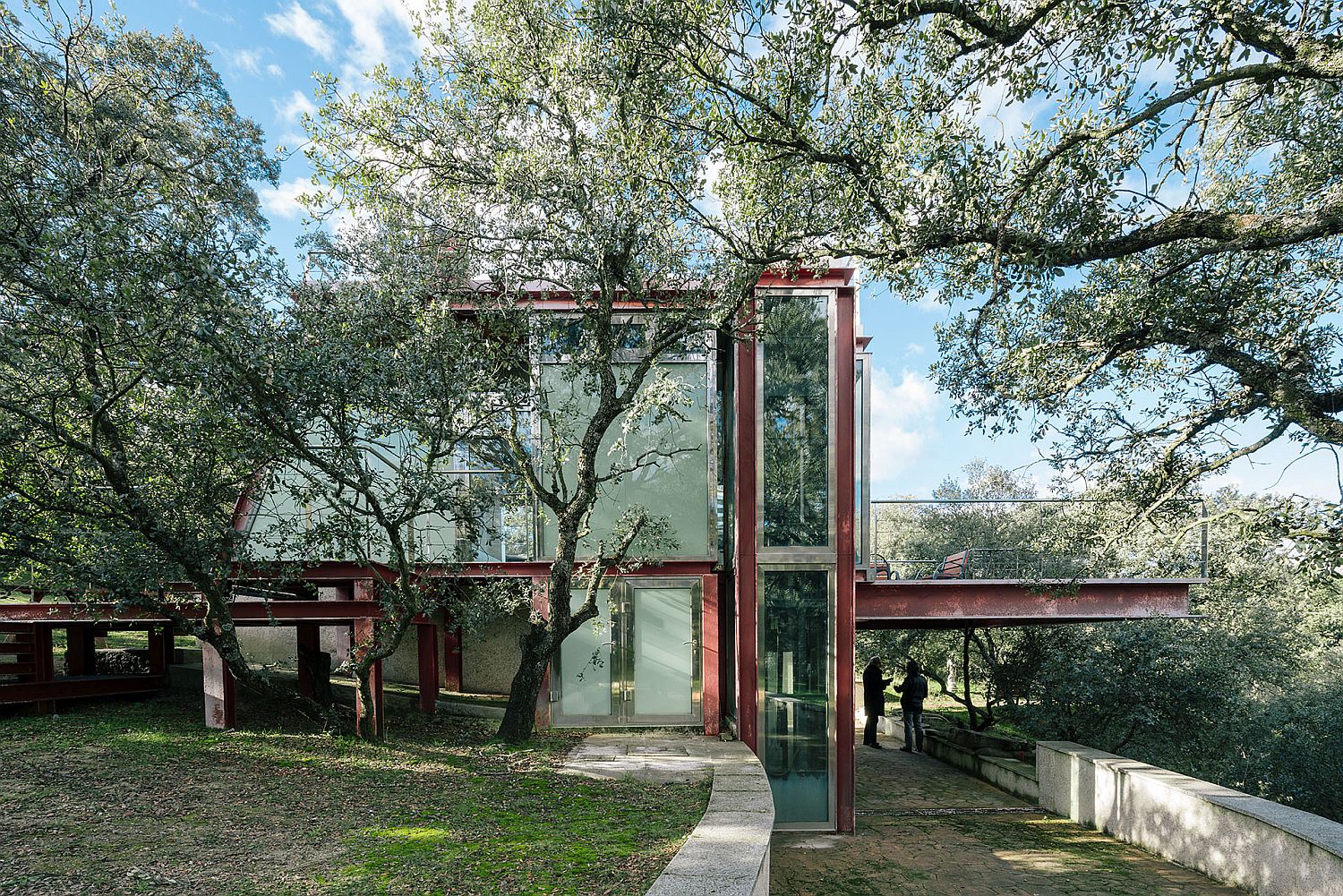 Stunning glass and metal design of The Hidden Pavilion surrounded by forest canopy