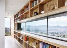 Wall-of-open-shelves-and-long-windows-combines-storage-with-captivating-views-217x155