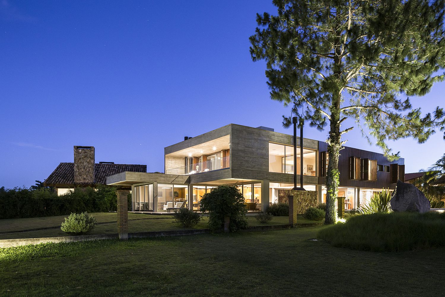 Warm lighting and green landscape elevate the style quotient of the Brazilian home