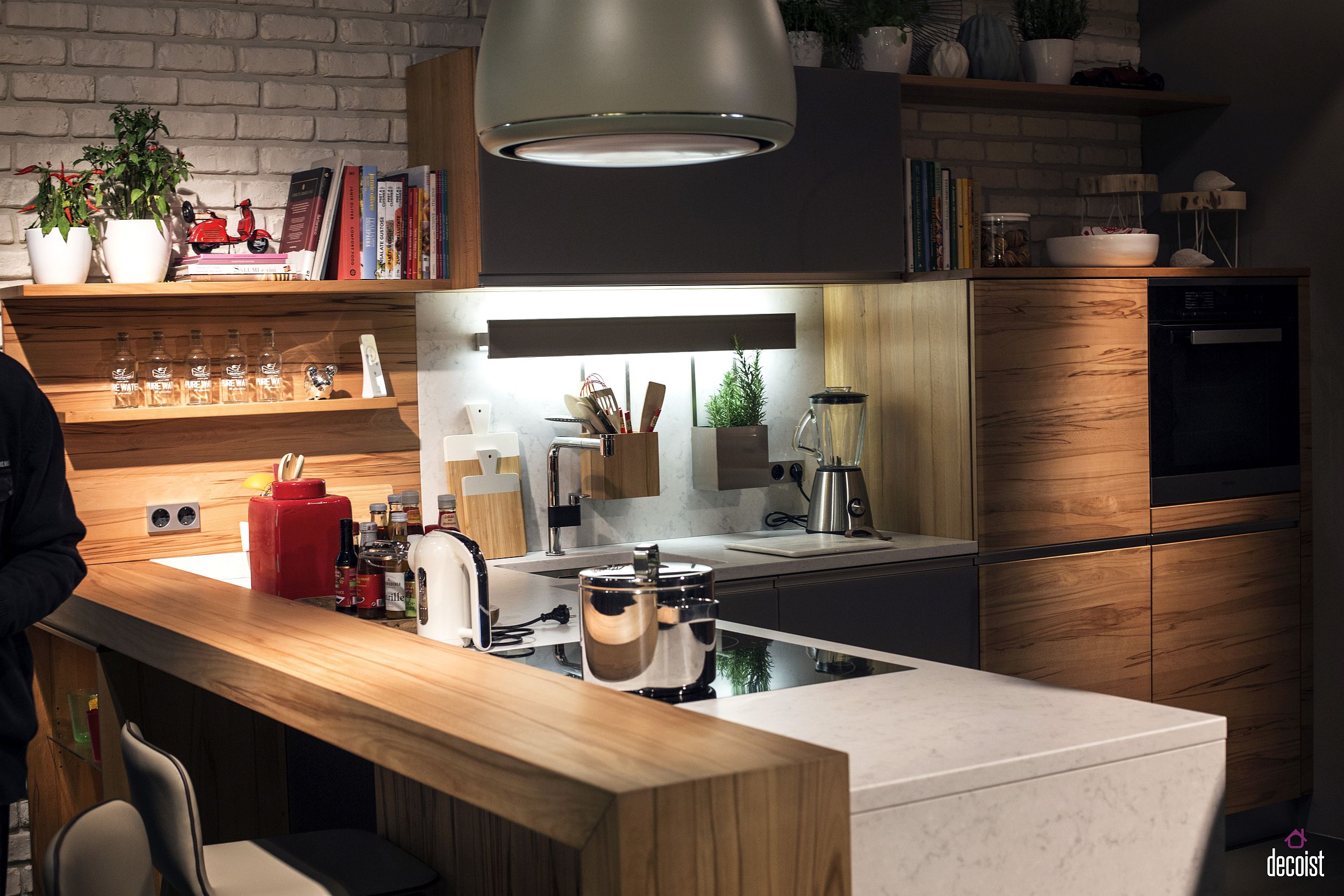 Wooden breakfast bar seems like a visual extension of the kitchen shelves and the worktop