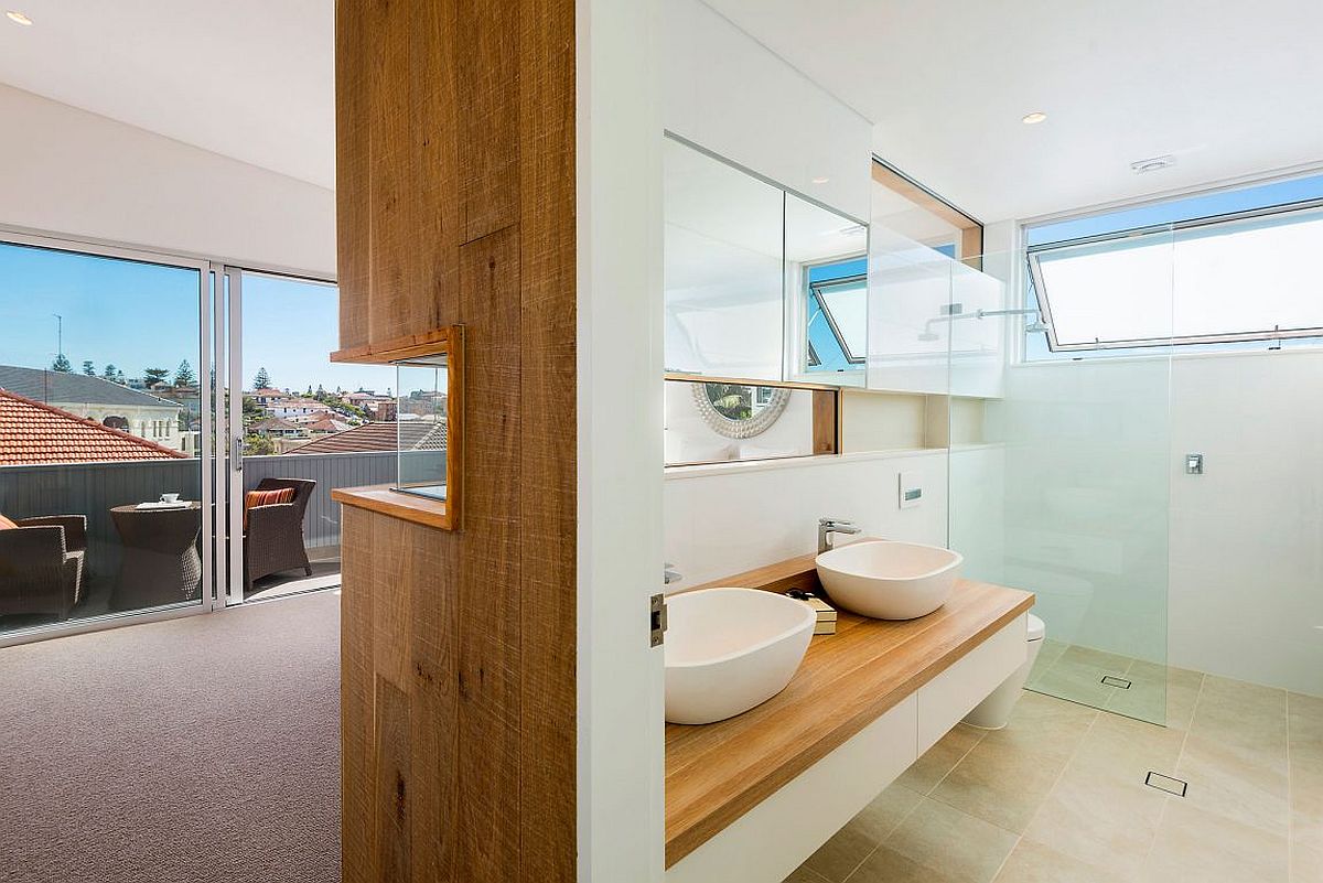 Wooden wall separates the bedroom from the master bath in style