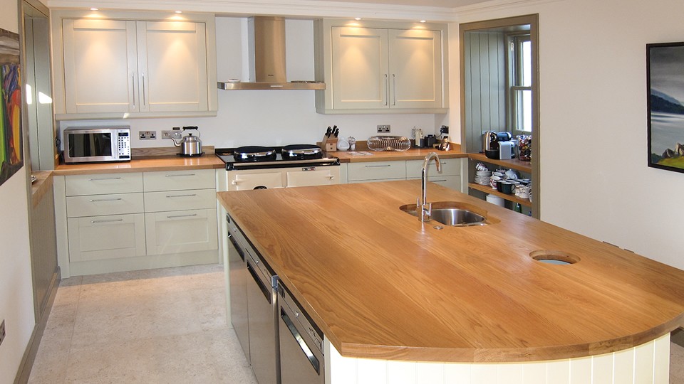 A big kitchen island with a bright wooden countertop