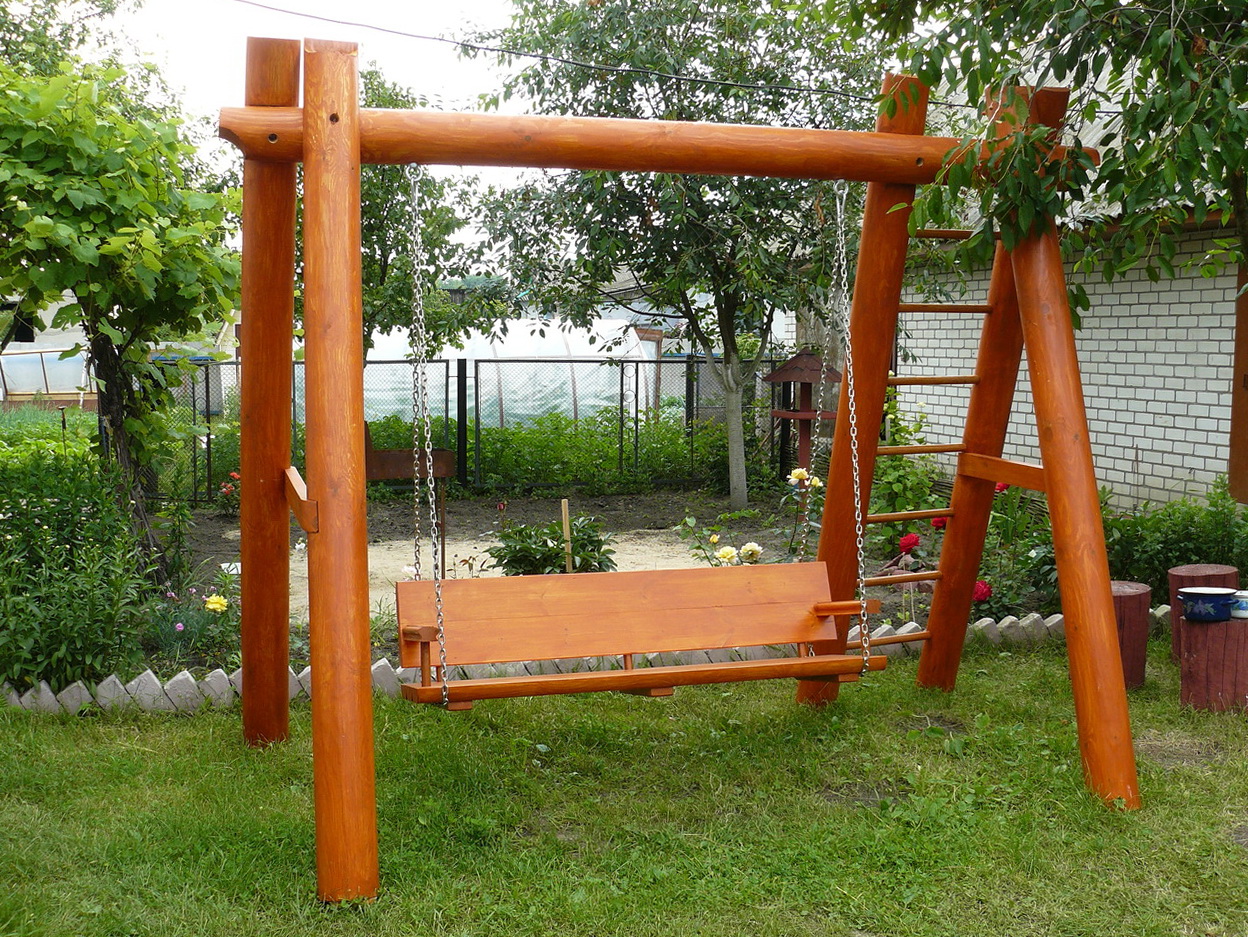 A rustic swing in a reddish shade of wood