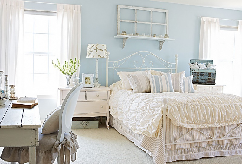 A white antique bedroom with a light blue wall