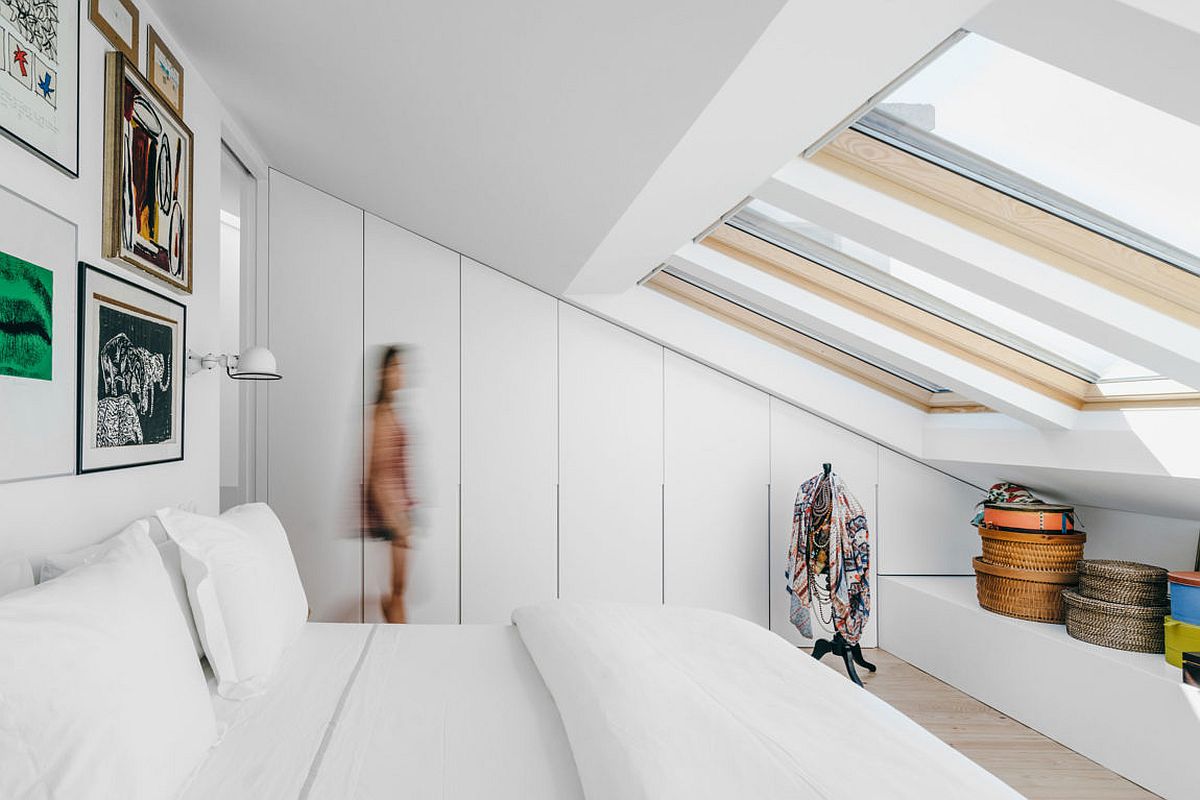 Attic in white bedroom with a series of skylights