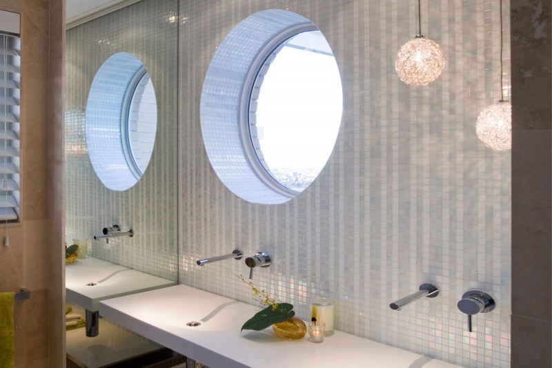 Bathroom with a round window right above the sink