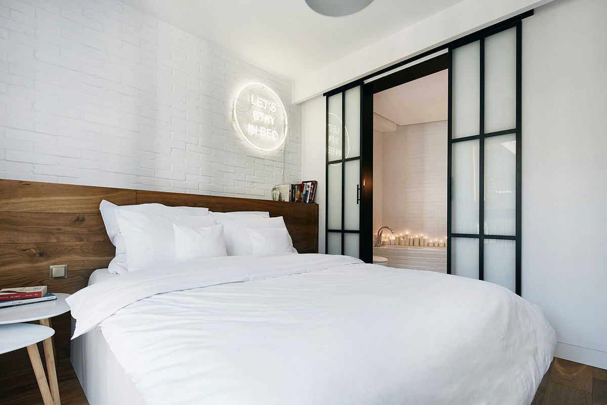 Contemporary bedroom in white allows the wooden headboard to stand out visually