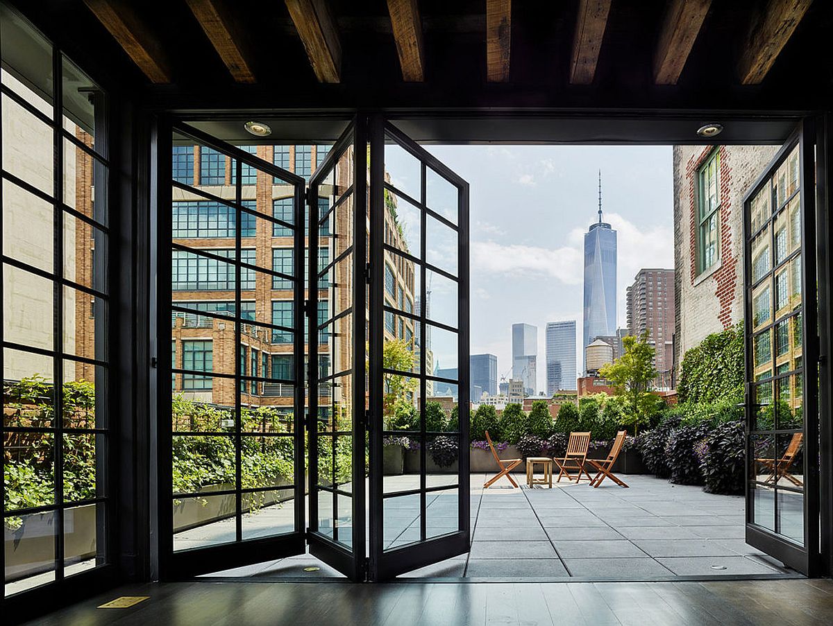 Folding framed glass doors give the New York pethouse industrial charm