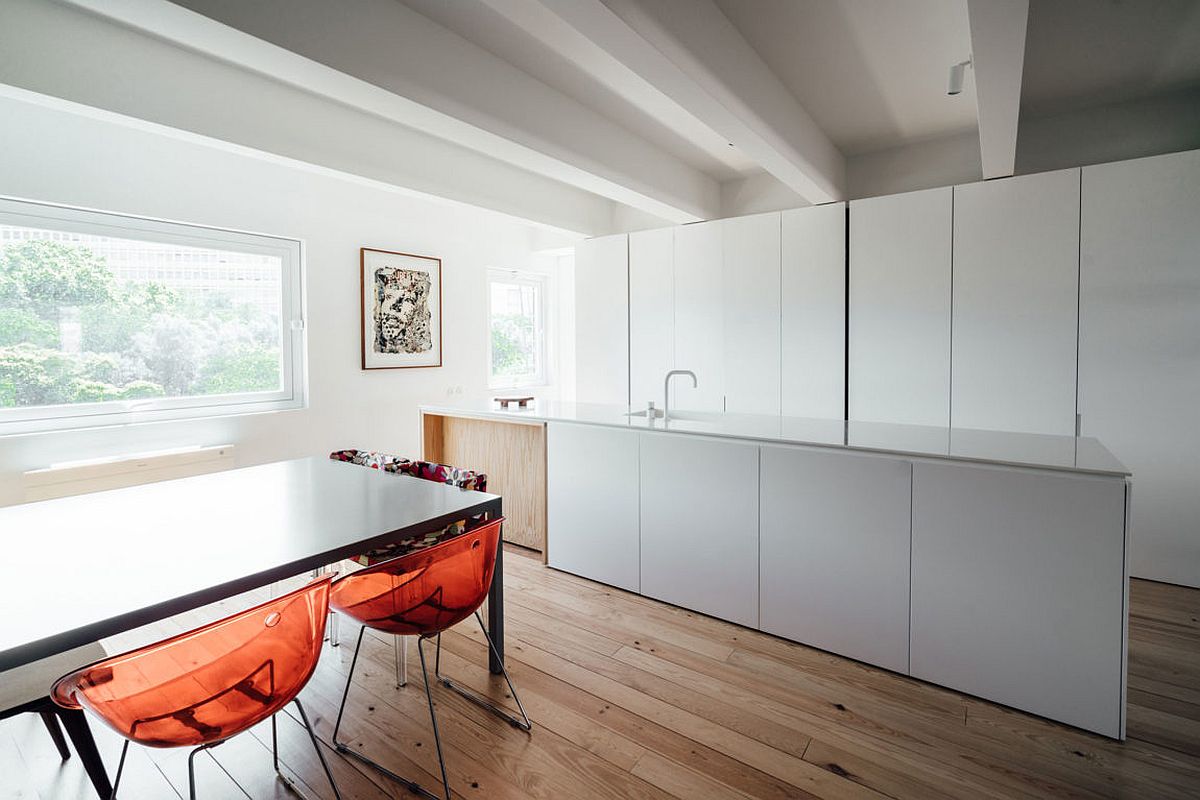 Fun dining table chairs bring pops of orange to the neutral interior