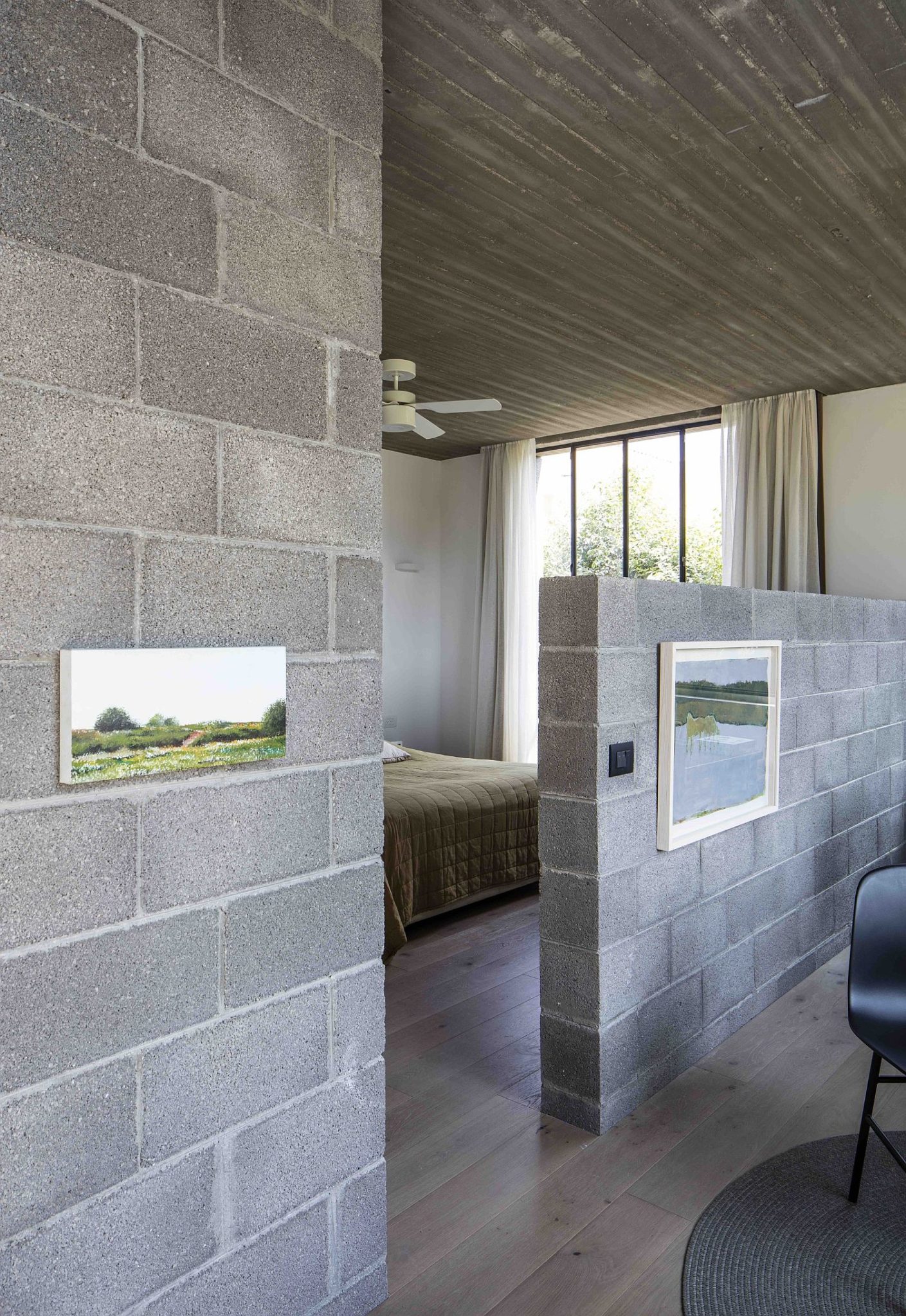 Half-wall delineates the bedroom from the master bath