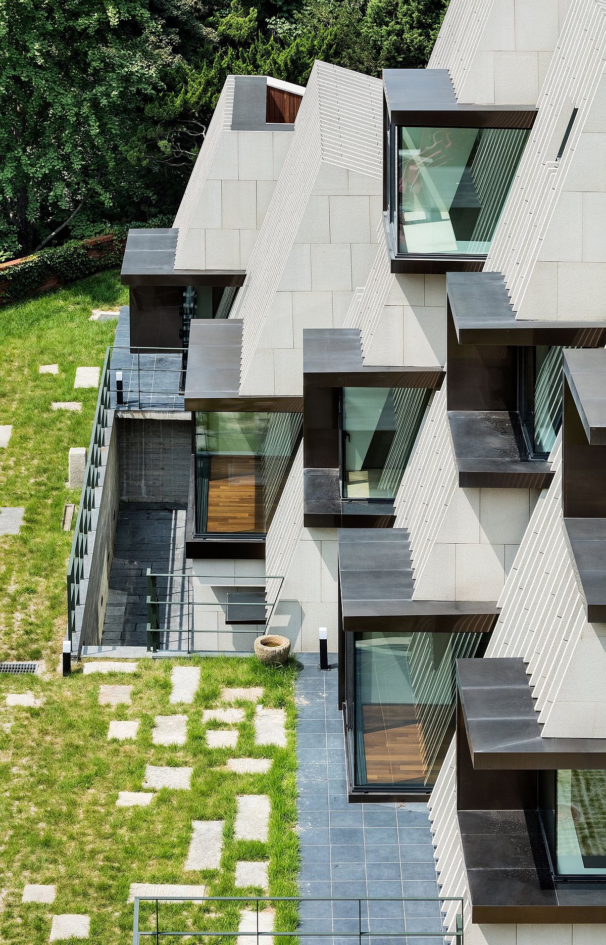 Metal and box-like windows shape the facade of the Deep House