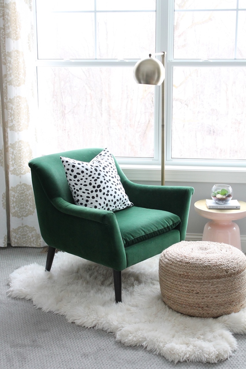 Minimalist reading nook with a dark green armchair