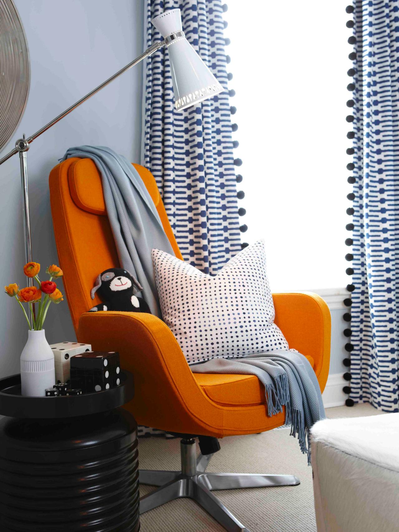 Minimalist reading nook with a vibrant orange chair