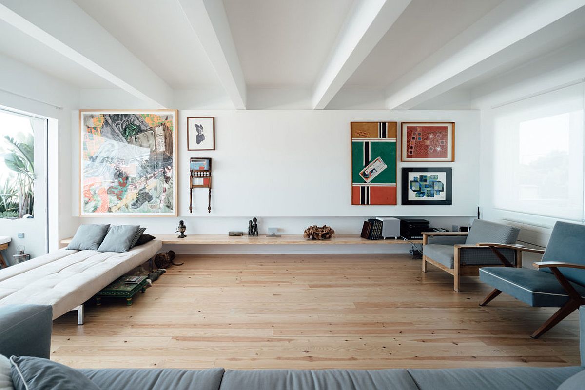 Sleek floating wooden shelf and colorful wall art inside the chic living space