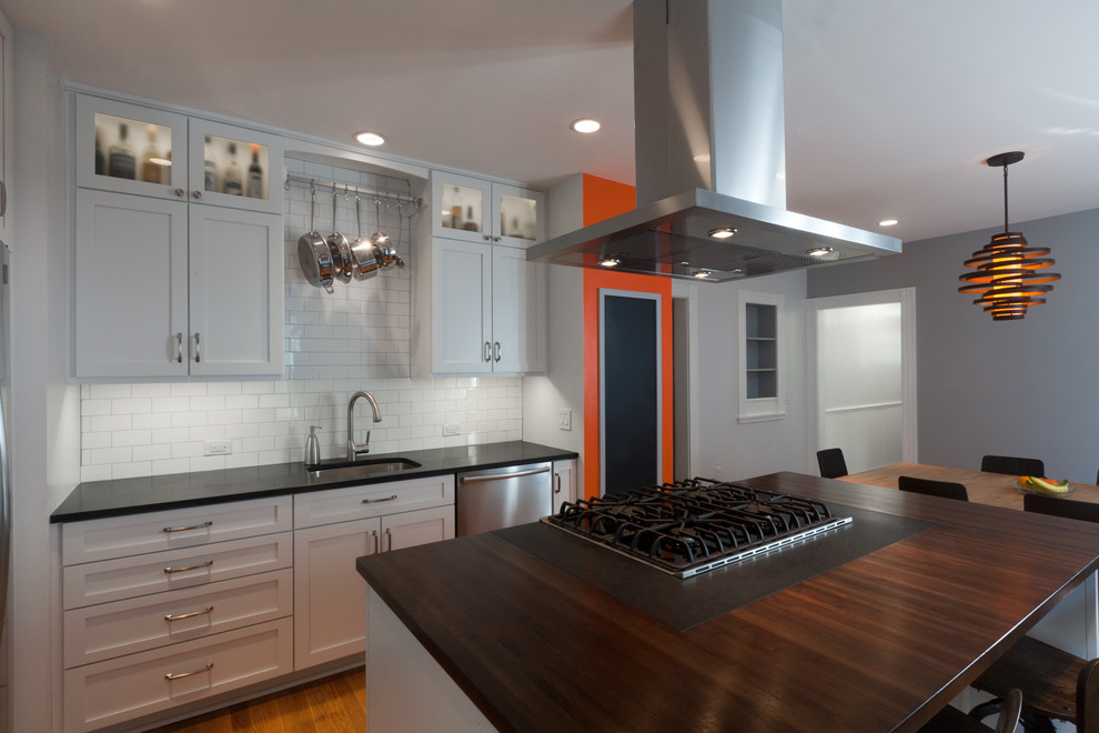 The modern minimalist kitchen is defined by the dark wooden countertop