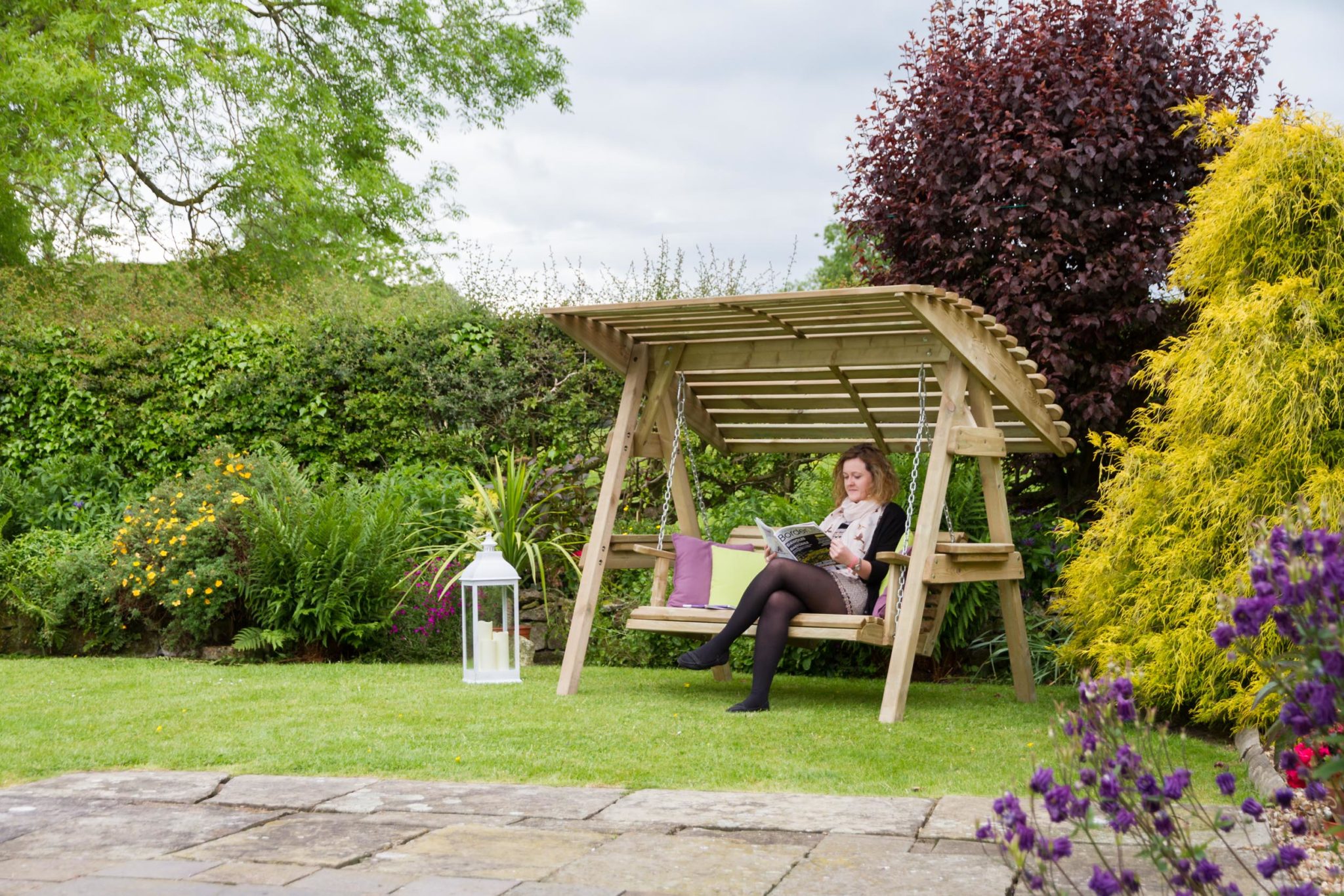 Wooden garden swing with a wide canopy