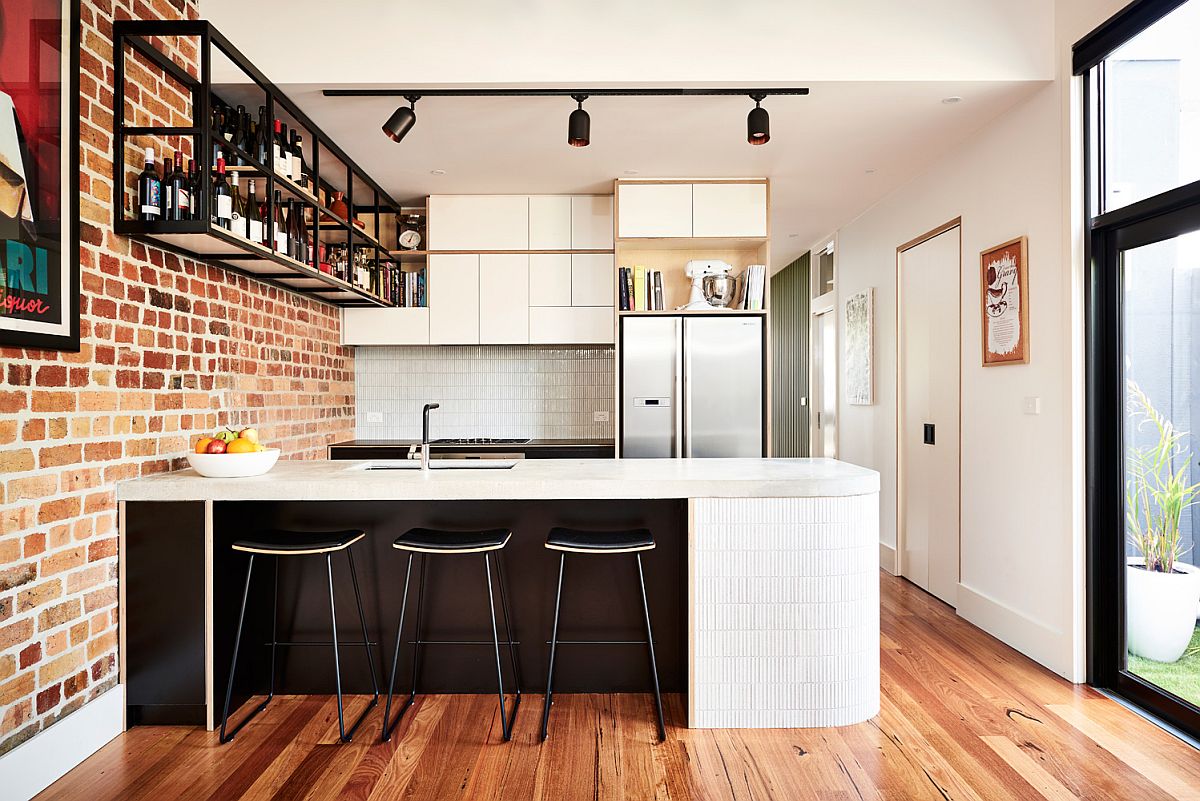 A curvy kitchen island adds contemporary flair to the industrial setting