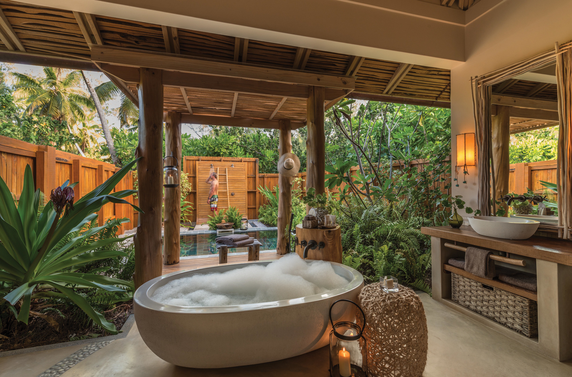 A full-size outdoor bathroom with a big tub and an open shower