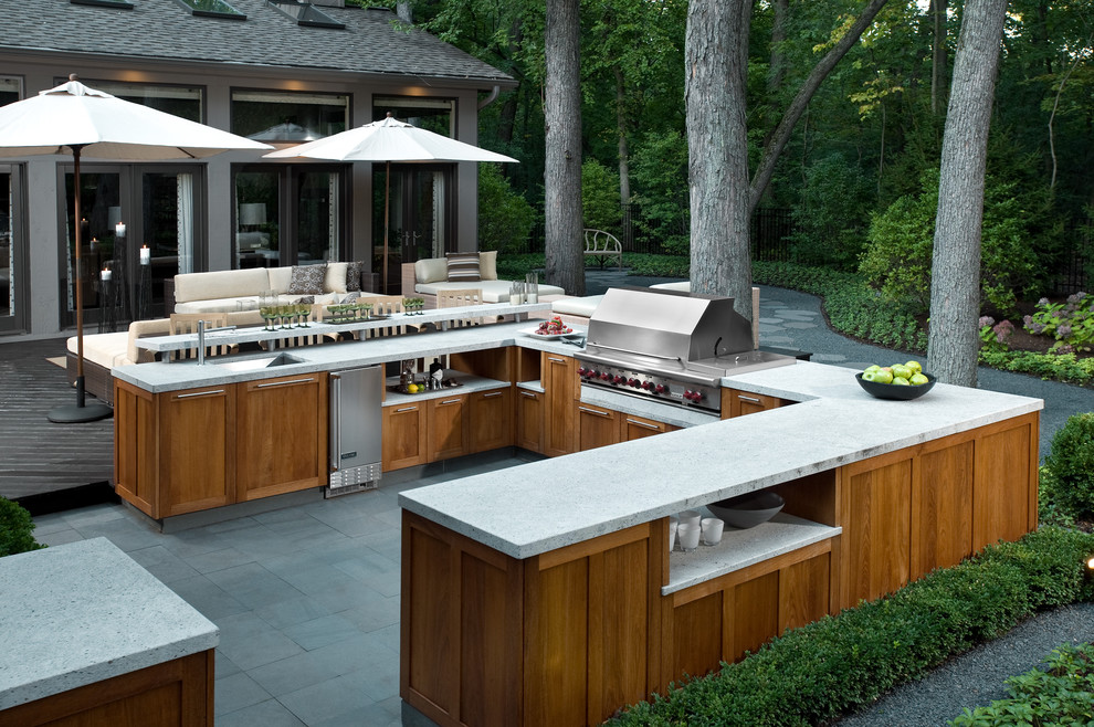 A full-sized outdoor kitchen with natural cabinets and contemporary counter