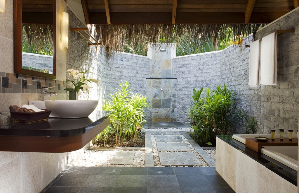 A half-covered outdoor bathroom with the shower as the focal point