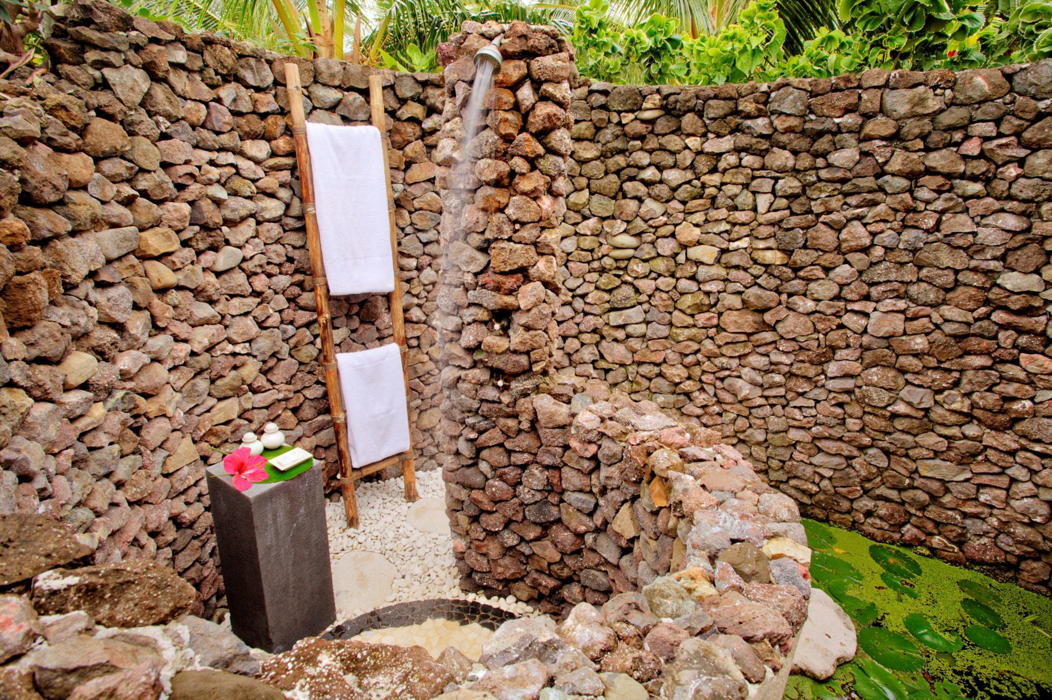 An outdoor shower made of countless little stones