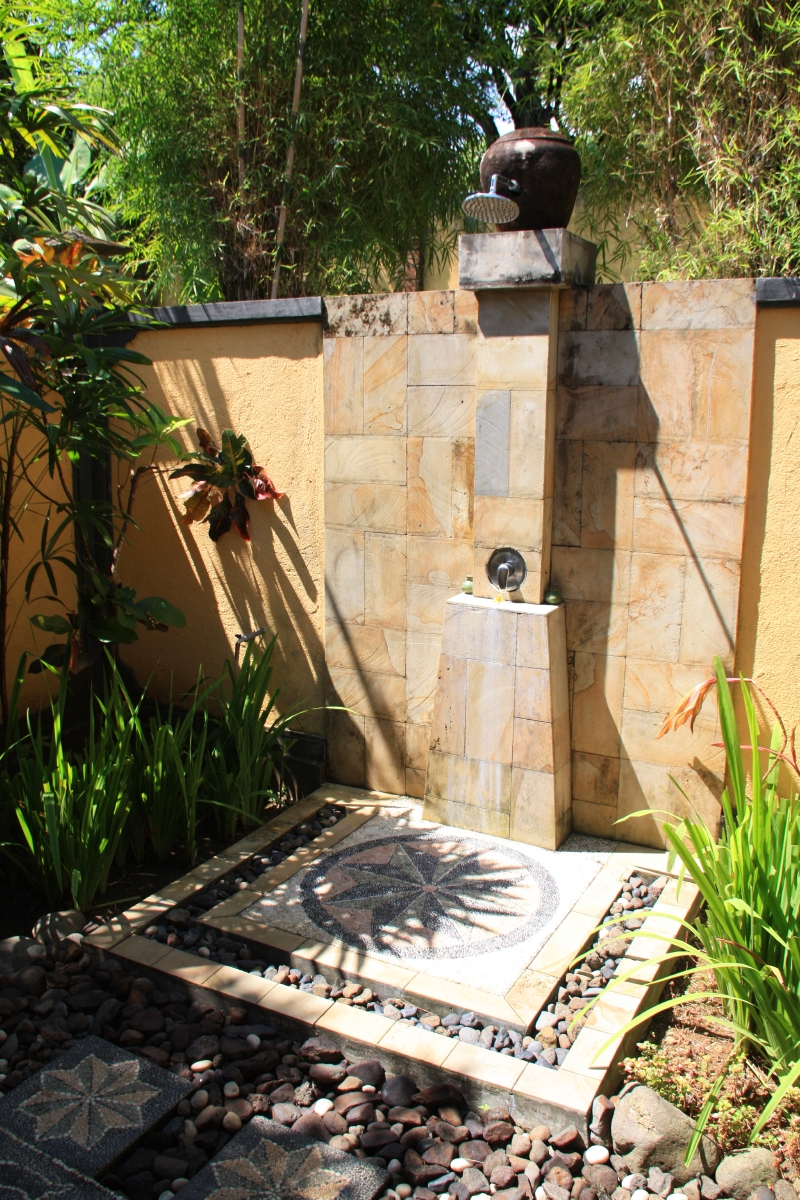 An outdoor shower with a warm color palette