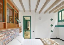 Bedroom-in-white-with-built-in-shelving-green-window-frames-and-ceiling-beams-217x155