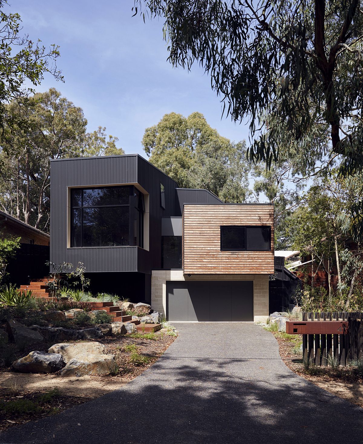 Cantilevered top level of the home with dark exterior stands out visually