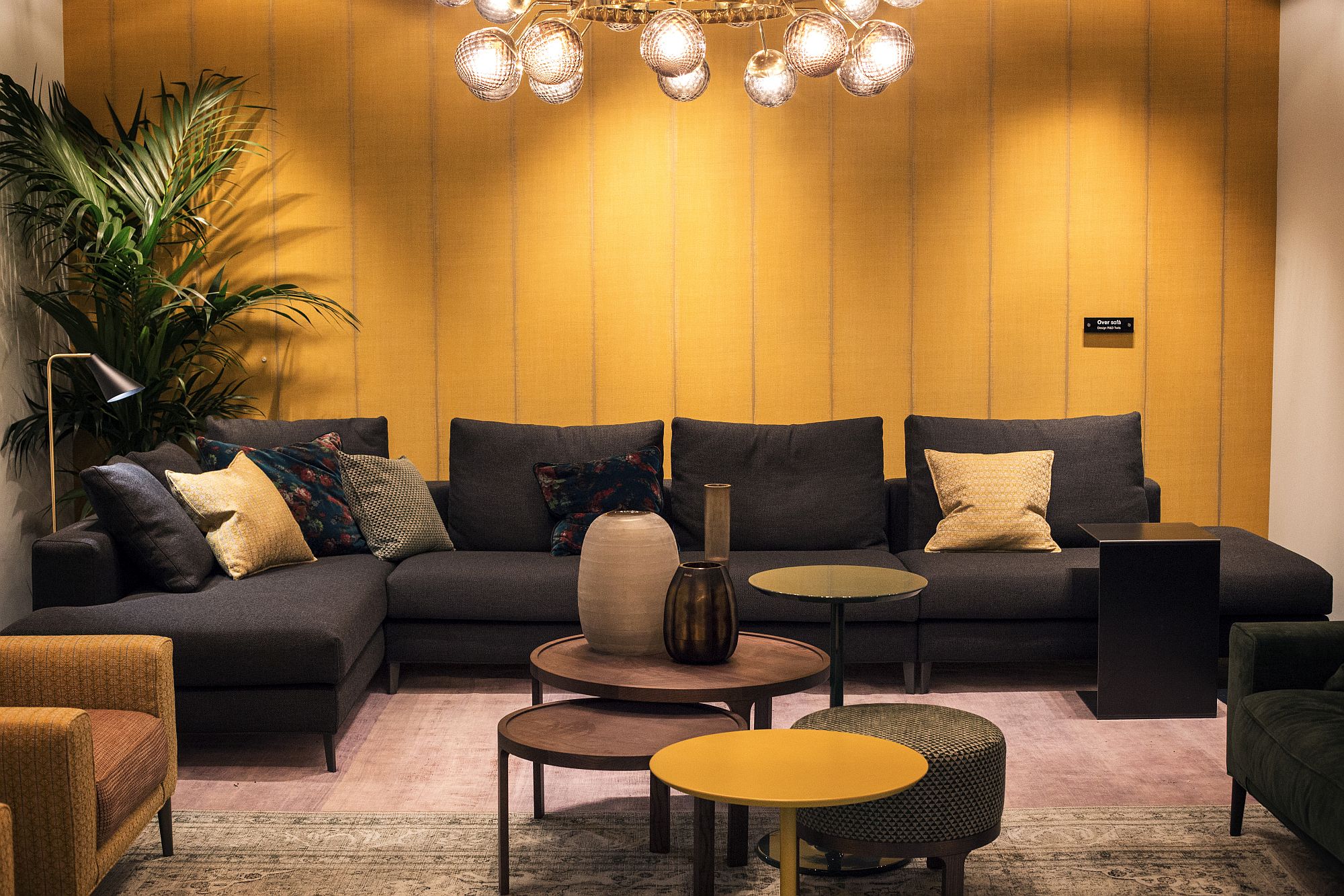 Cool orange coffee table complements the backdrop even as black couch brings style and elegance