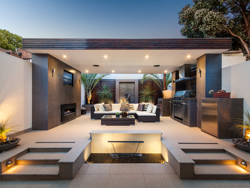Modern outdoor kitchen doubling as a cozy lounge corner