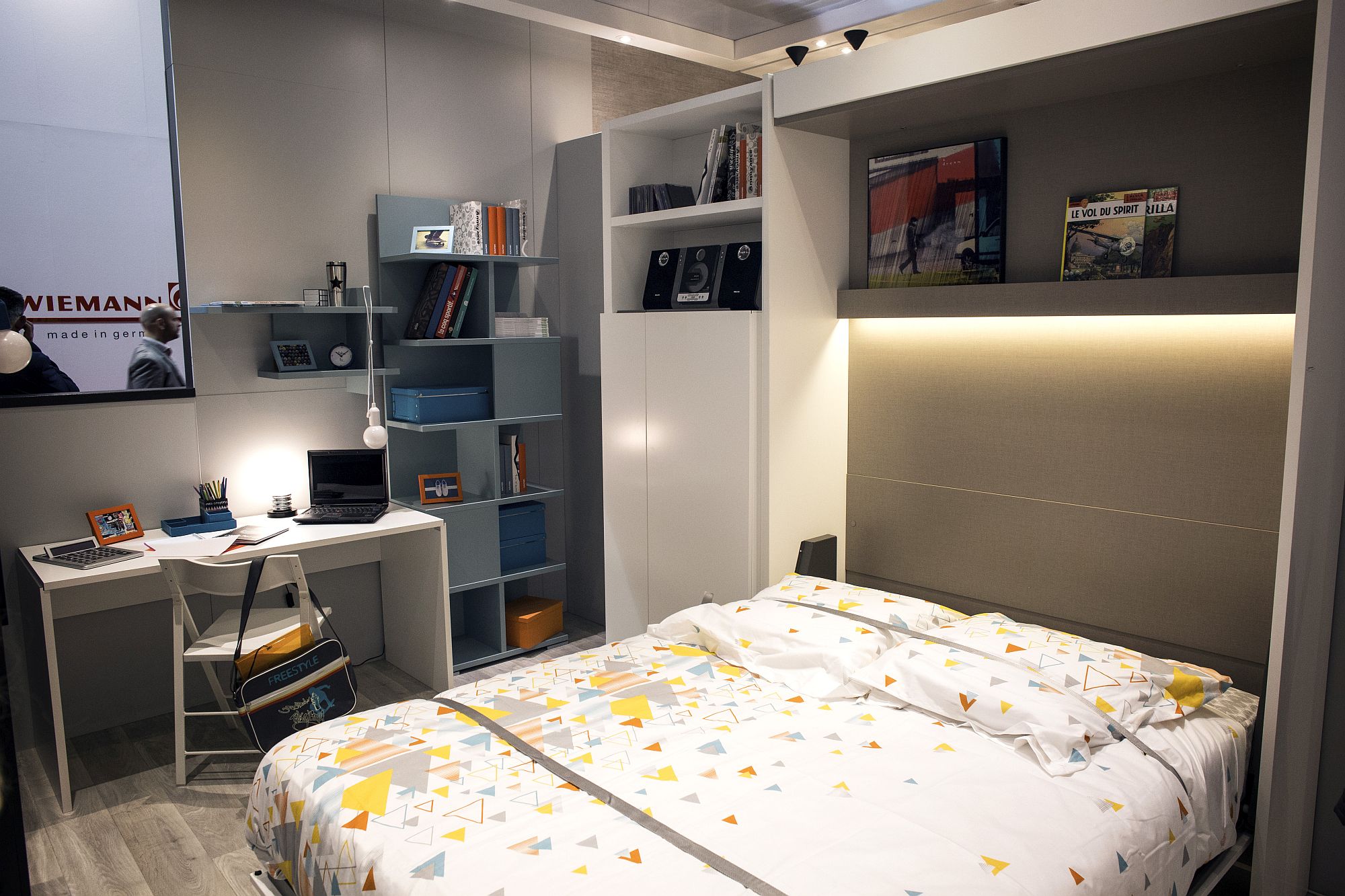 Open shelves are coupled with work station and corner wardrobe in this modern tween room