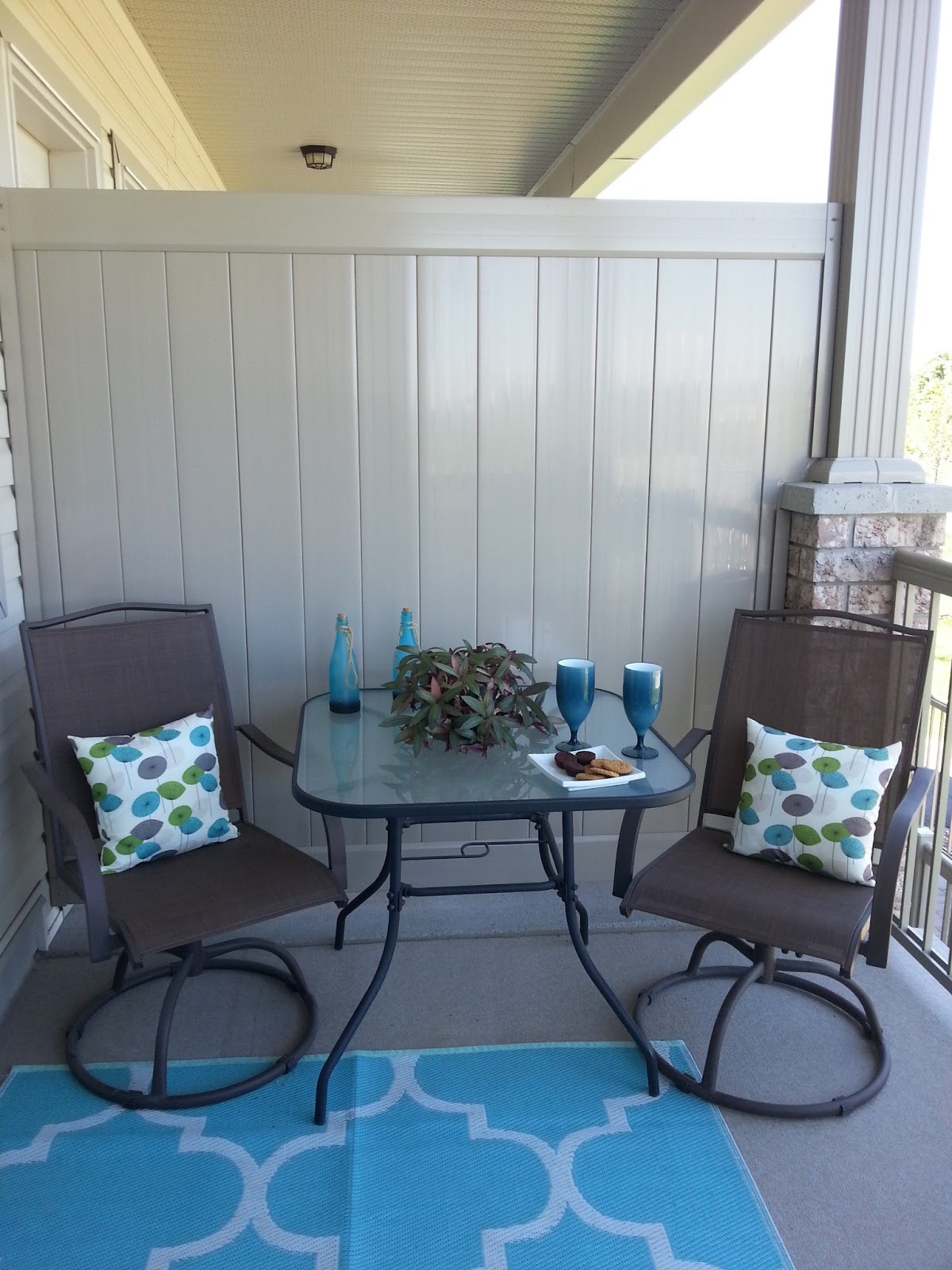 Small neutral balcony with a daring blue rug and light cushions